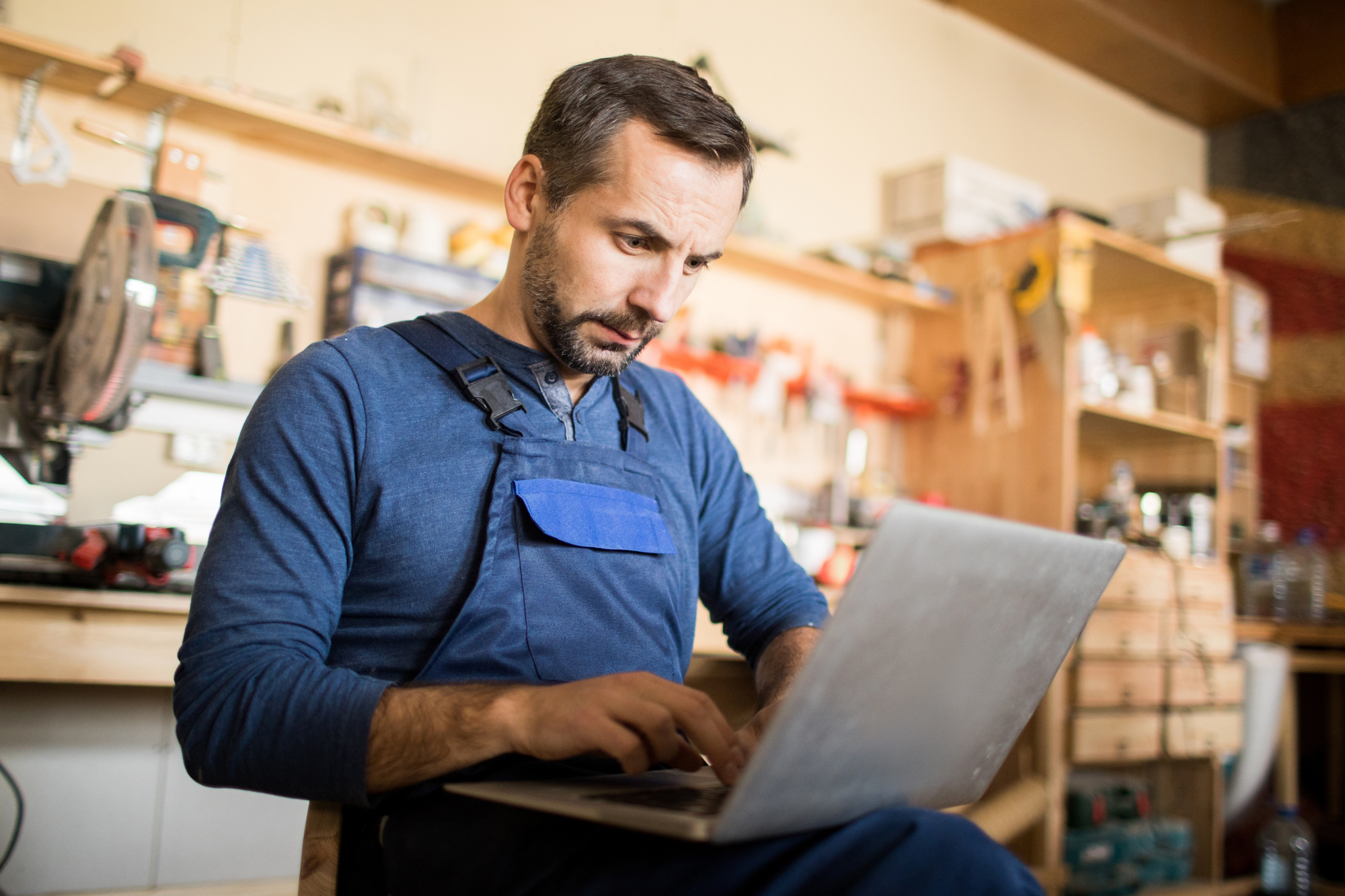 A small business owner reviews various managed SOC providers online, while working remotely from a home office