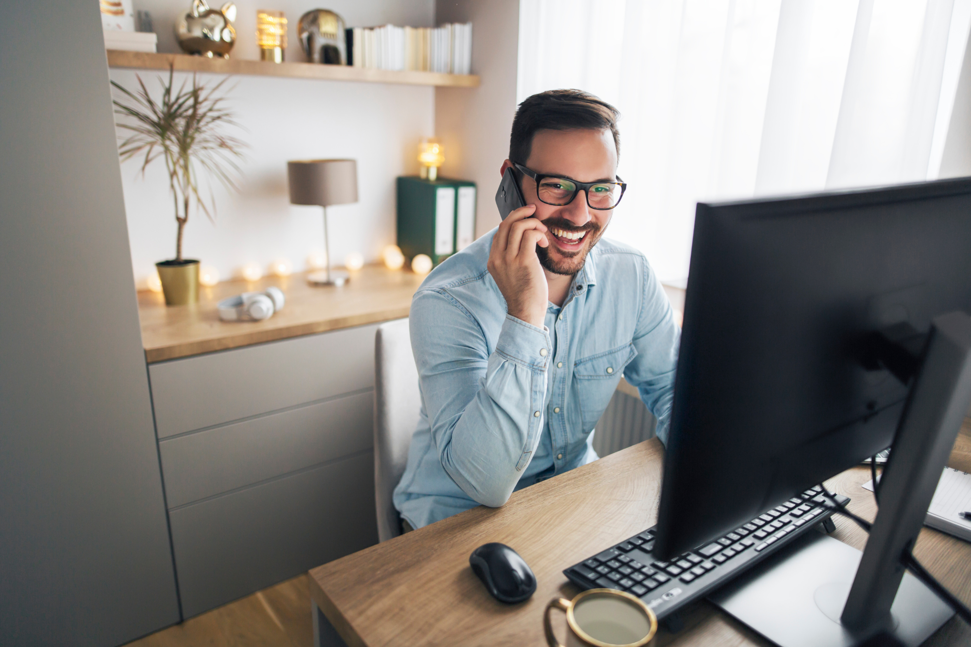 A small business owner working from a laptop while a remote IT team manages their technology needs from a distance