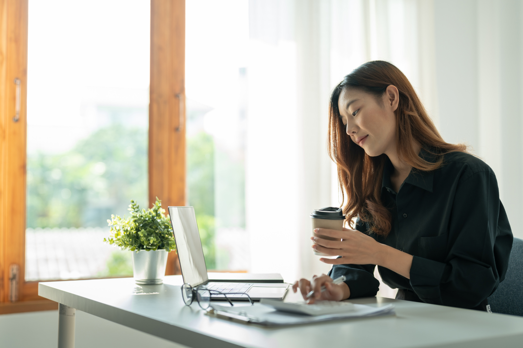 A small business owner working from home, surrounded by technology and facing the challenges of managing a remote workforce during COVID-19