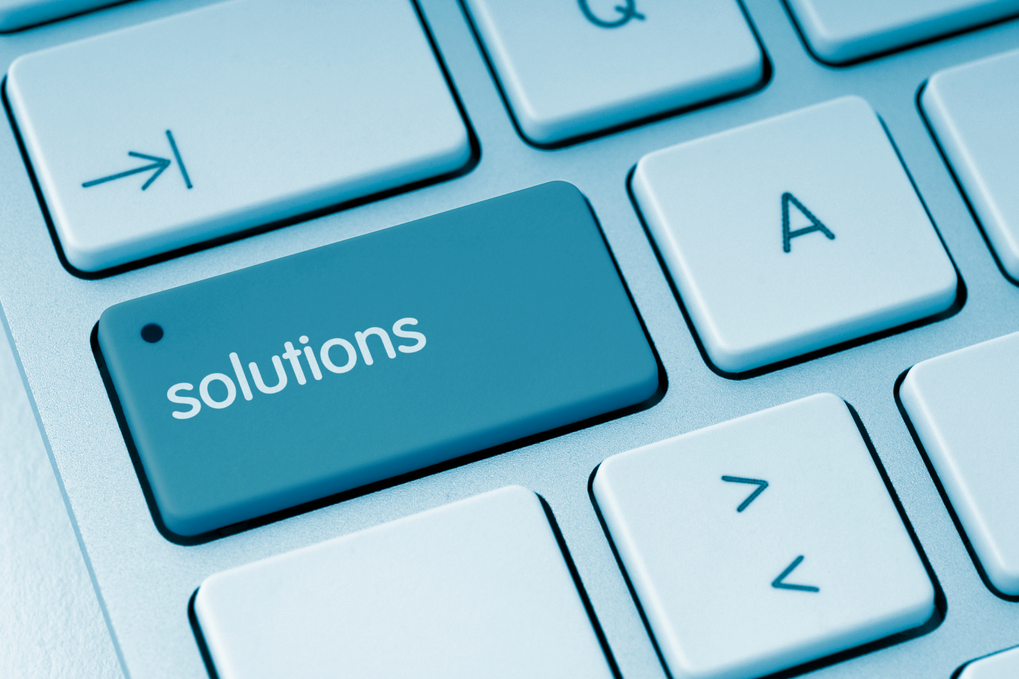 A small business owner working on a laptop in a cozy home office with a remote business IT solution provider logo on the screen