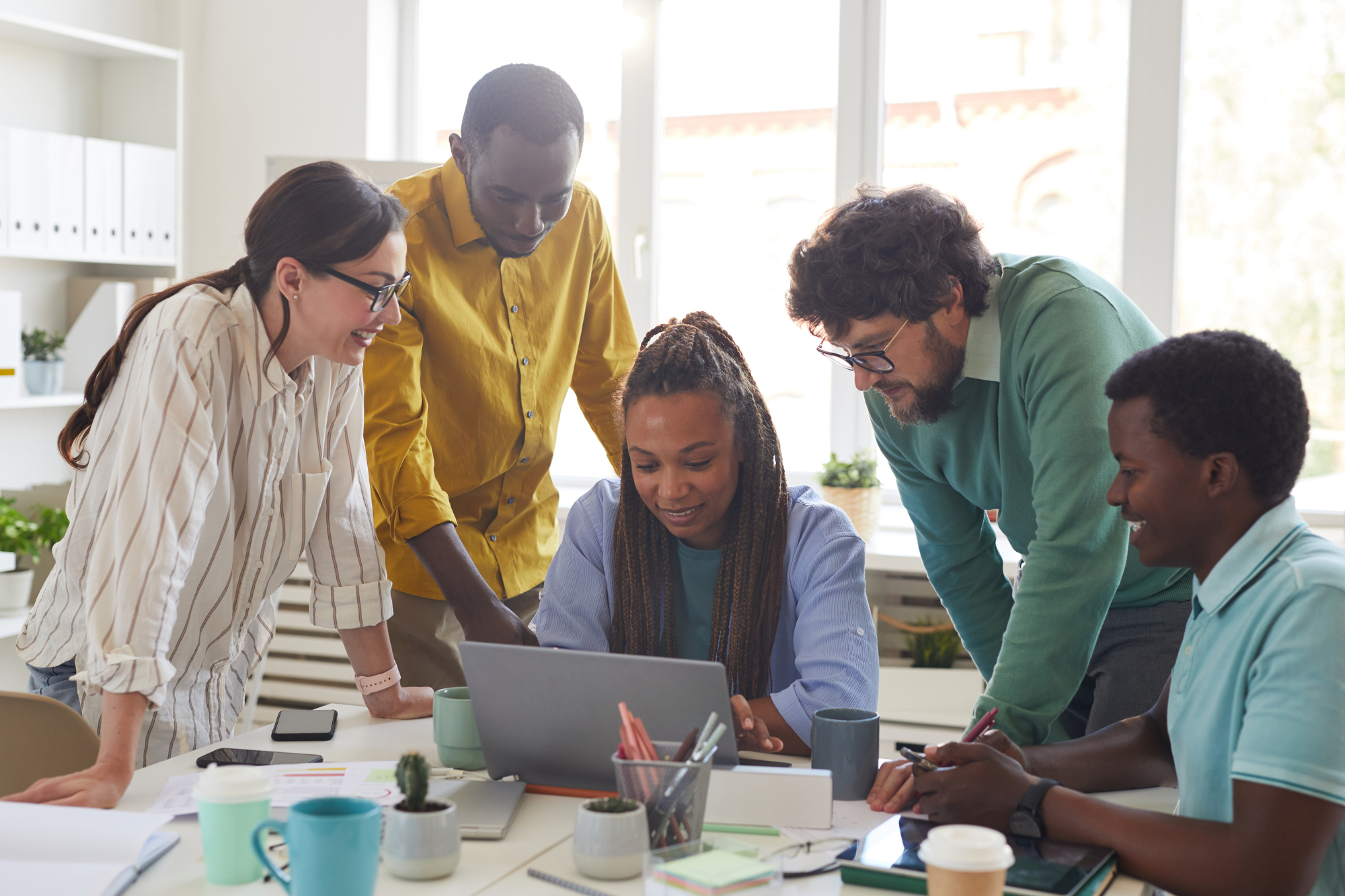 A group of diverse business professionals using various digital collaboration tools to work together remotely