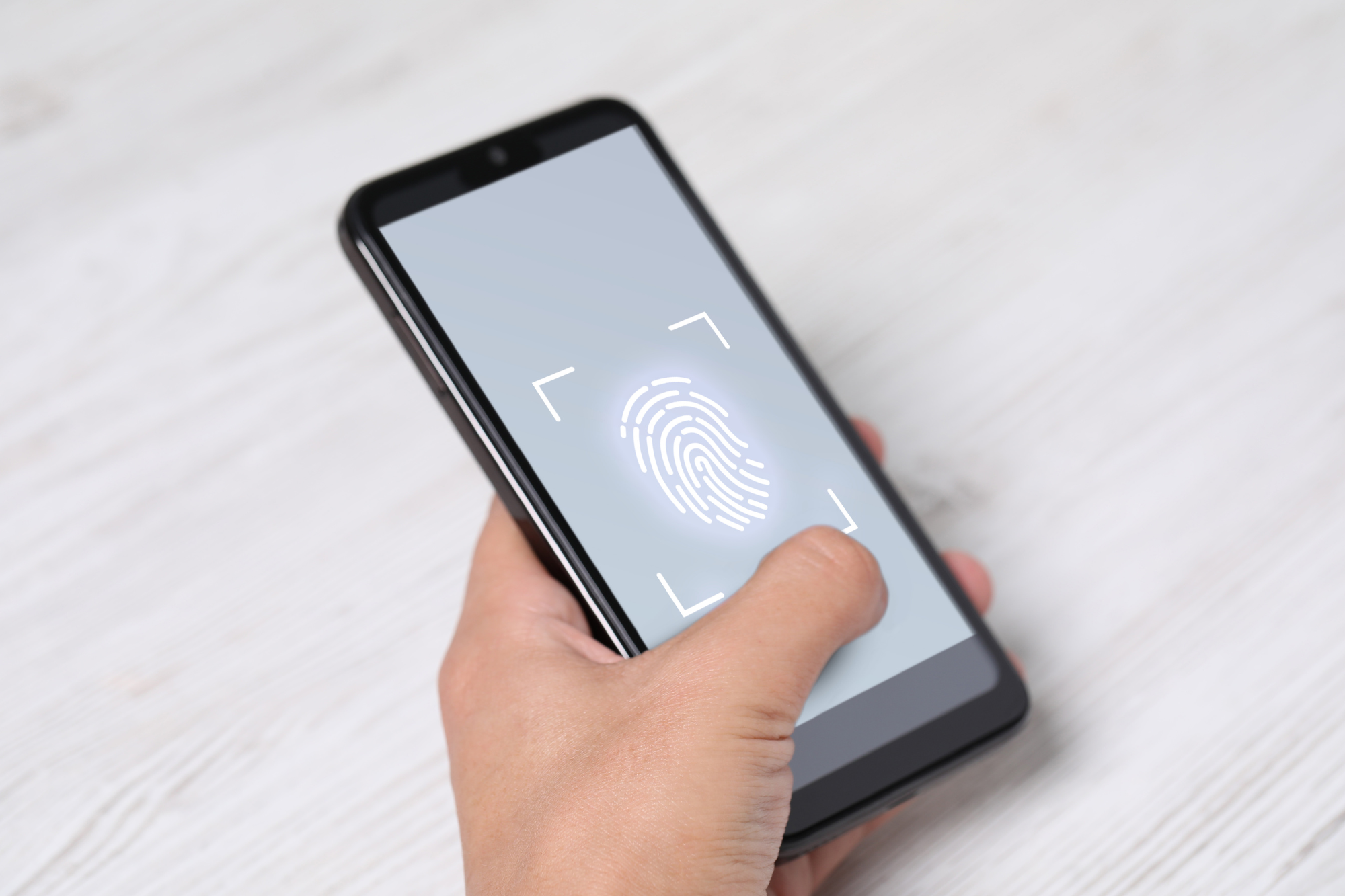 A smartphone displaying a two-factor authentication app with a fingerprint scanner and a text message code