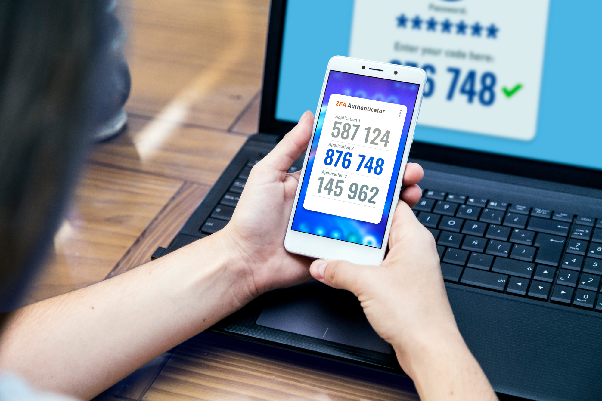 A person holding a smartphone with a multifactor authentication app open, while another device prompts for verification